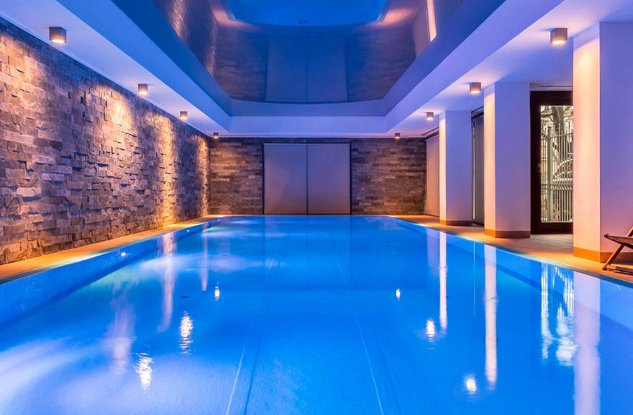 Indoor pool with blue lighting and modern design.