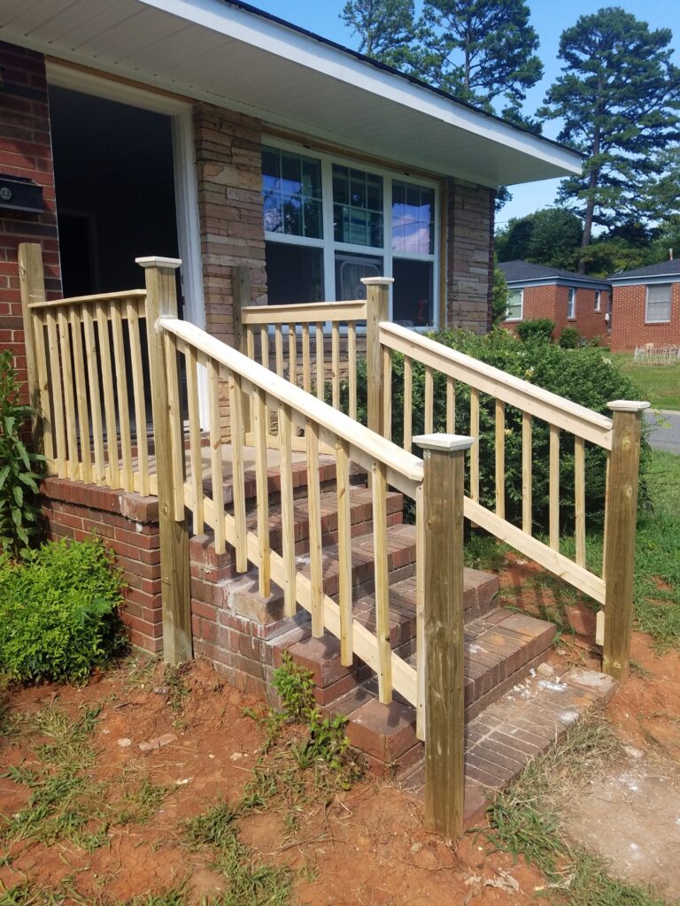 Wooden handrails installed on outdoor steps leading to a porch.