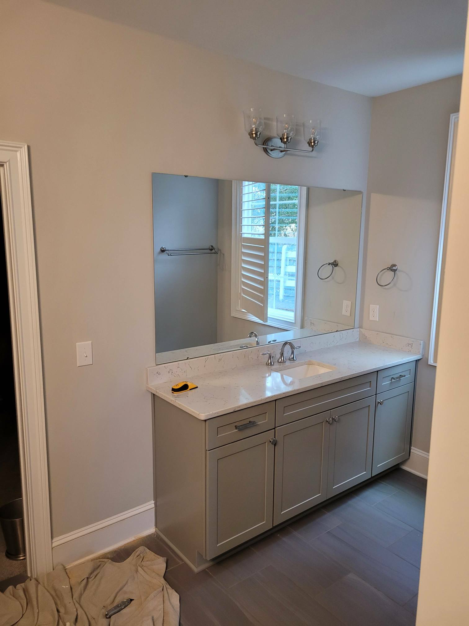 Modern bathroom vanity with double sinks and large mirror.