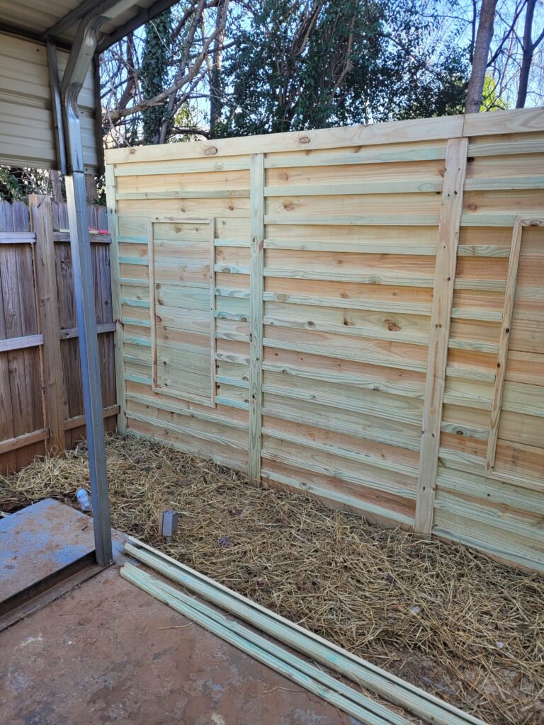 Newly installed wooden fence panels in a backyard.